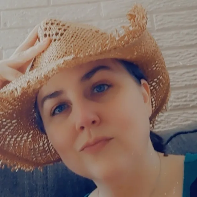 headshot of Cassidy smiling in a straw hat